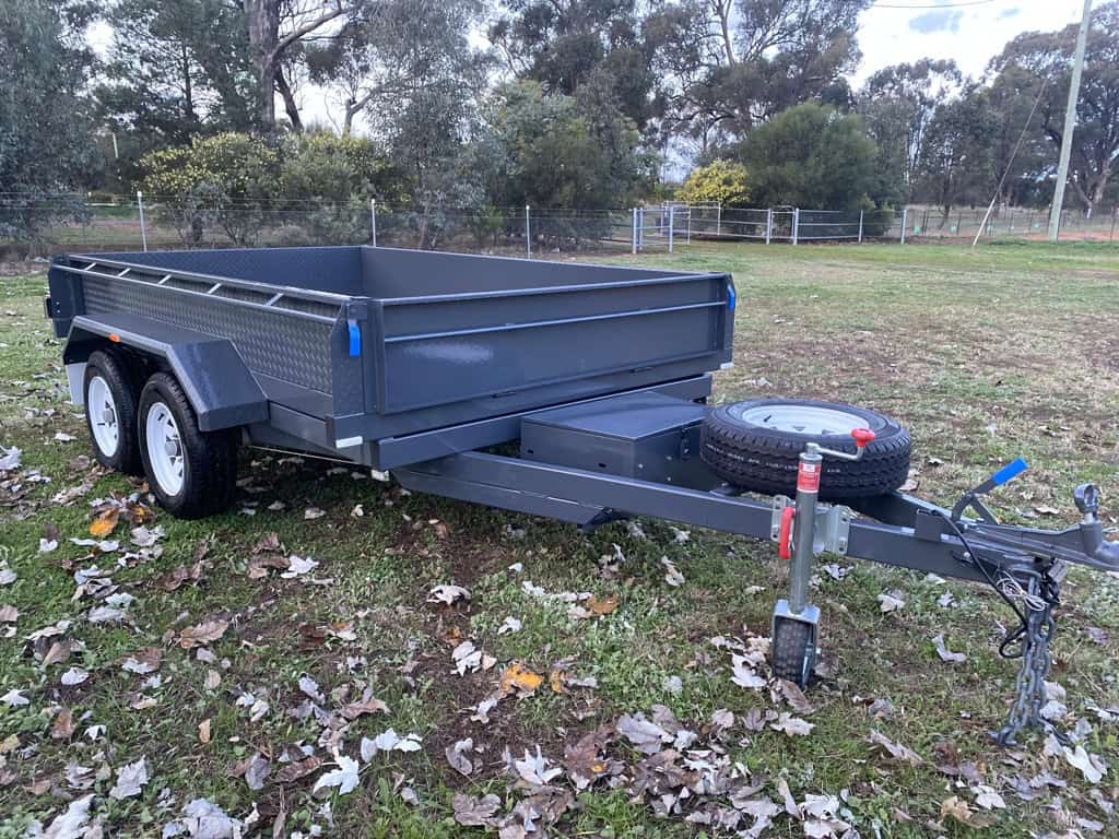 Dual axle box trailer parked on grass.